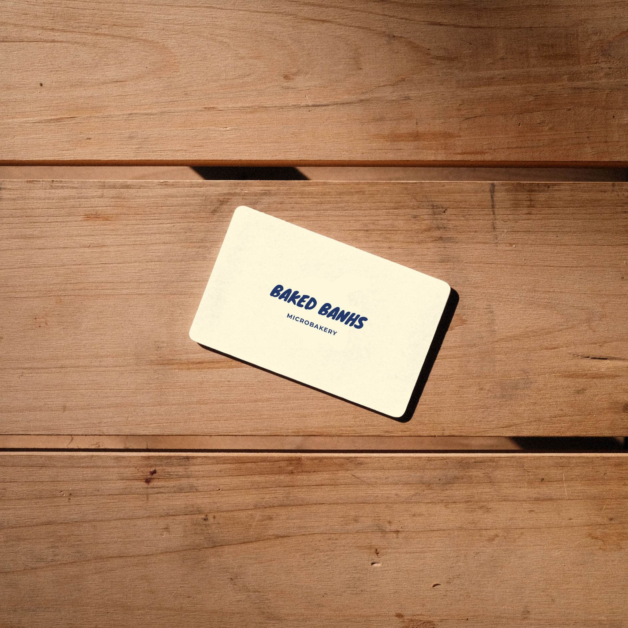 A top down view of a Baked Banhs Gift Card on a wooden table
